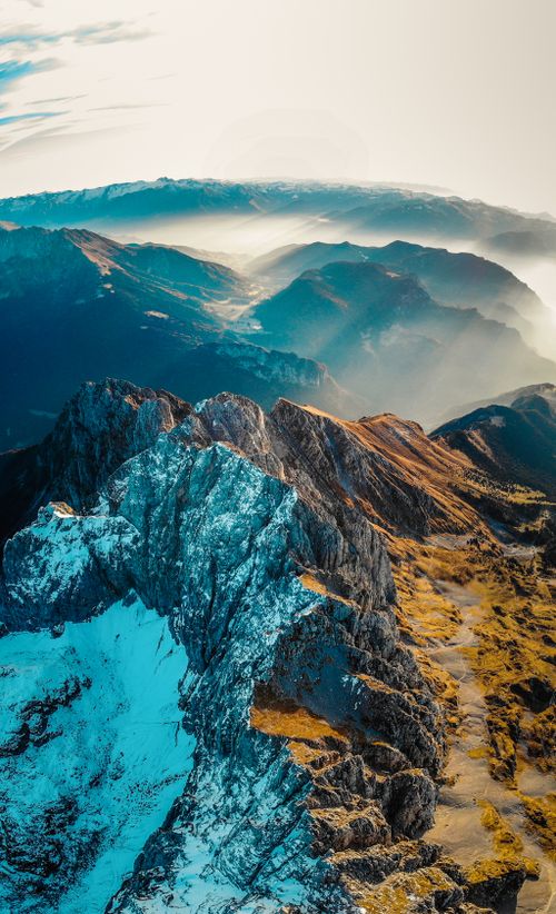 Free Breathtaking aerial view of a mountain range with snow and sunlight in Lombardy, Italy. Stock Photo