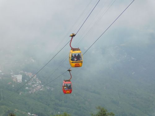 Free Two colorful cable cars suspended over misty mountains in Darjeeling, India. Stock Photo