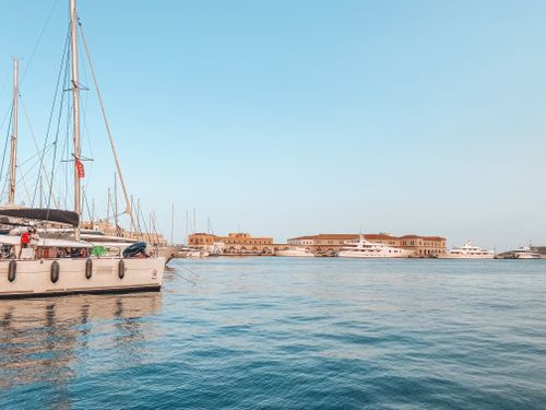 Free A scenic view of luxury yachts docked at a harbor with a clear blue sky. Stock Photo