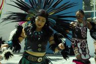 Woman in Black and Green Dress With Blue and White Feather Headdress