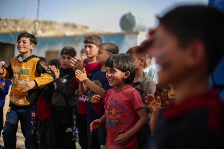 Group Of Boys Watching And Clapping Their Hands