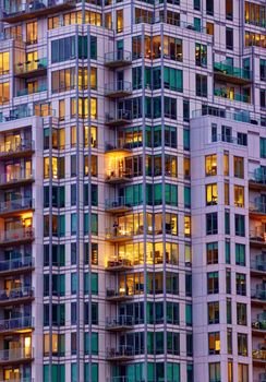 Detailed view of a lit high-rise residential building in Halifax during dusk, showcasing urban life.