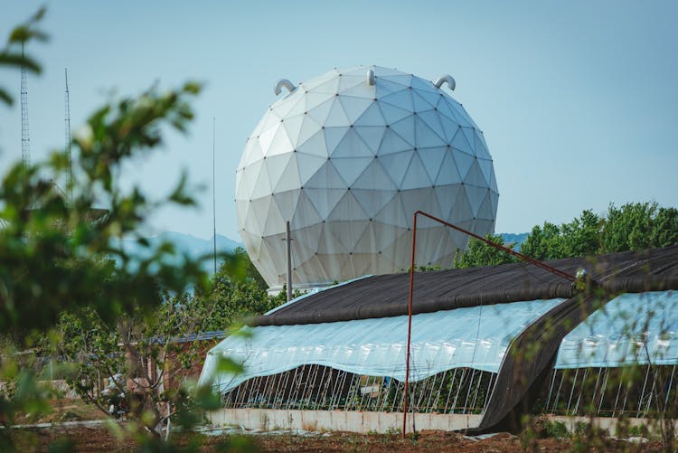 Globe-Shaped Building Near Greenhouses