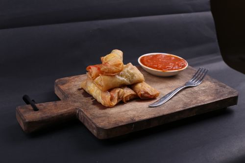 Free Tasty fried spring rolls served with a spicy dipping sauce on a wooden board. Stock Photo