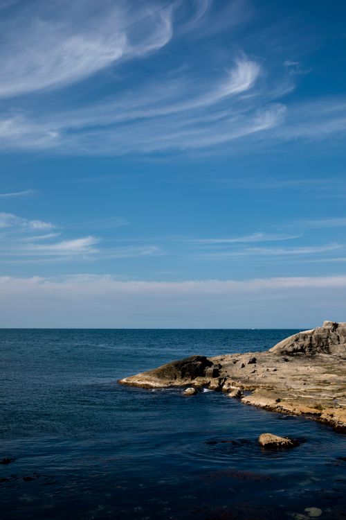 Free Scenic coastal view of Sokcho's rocky shore and blue sky in South Korea Stock Photo