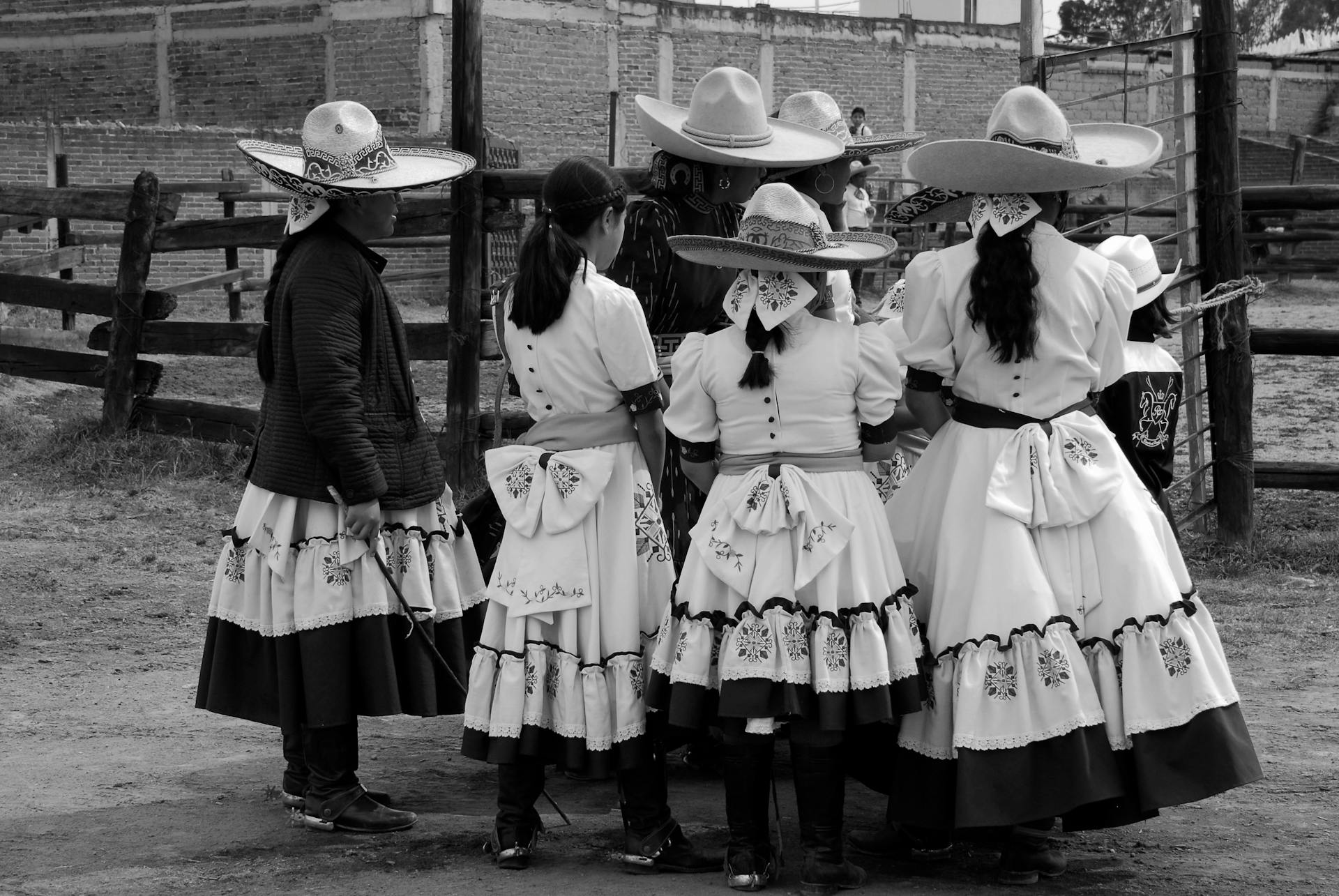 Grayscale Photo of Women Wearing Traditional Dresses and Hats