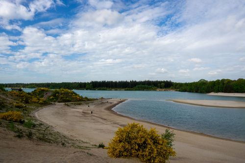 Free Explore the tranquil scene of a lake with sandy shores under a cloudy sky, captured outdoors. Stock Photo