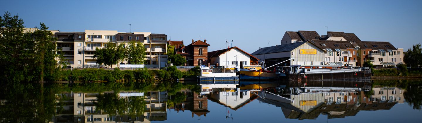 Scène tranquille de bâtiments se reflétant sur un lac à Compiègne, France.