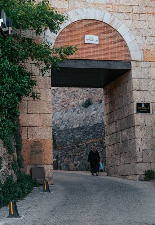 Free Back View of a Woman Walking Carrying a Plastic Bag Stock Photo