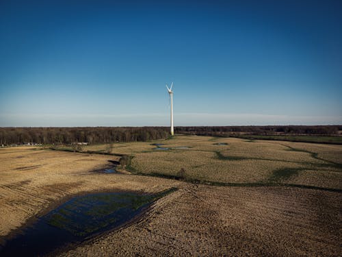 Wind Turbine on Brown Grass Field Under Blue Sky