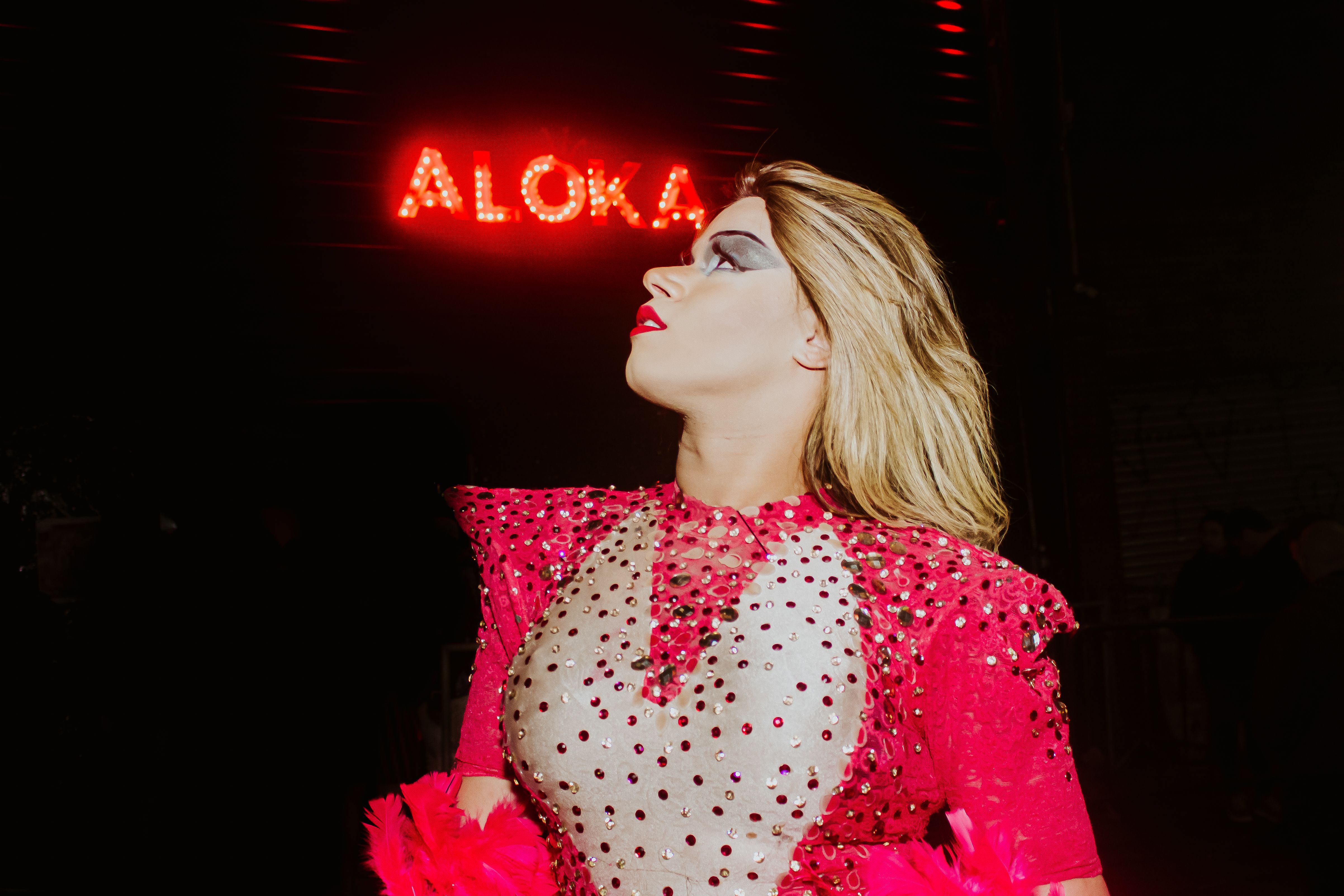 Portrait of a performer in a dazzling costume at a vibrant night event in São Paulo.
