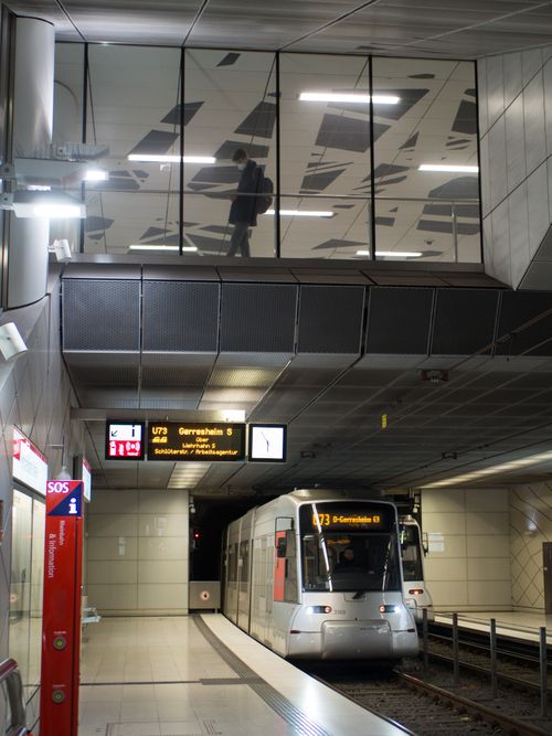 Free A sleek tram arrives at a modern city underground station with reflective ceilings and signage. Stock Photo