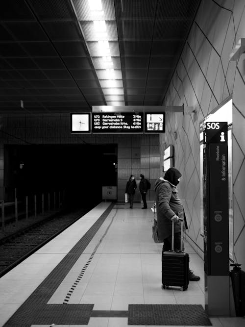 Grayscale Photo of People Waiting on a Platform