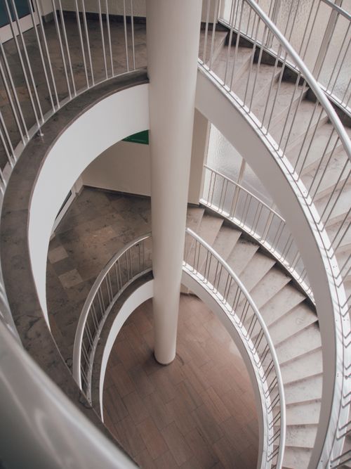 Free Elegant spiral staircase with metal handrails, seen from above, showcasing architectural design. Stock Photo