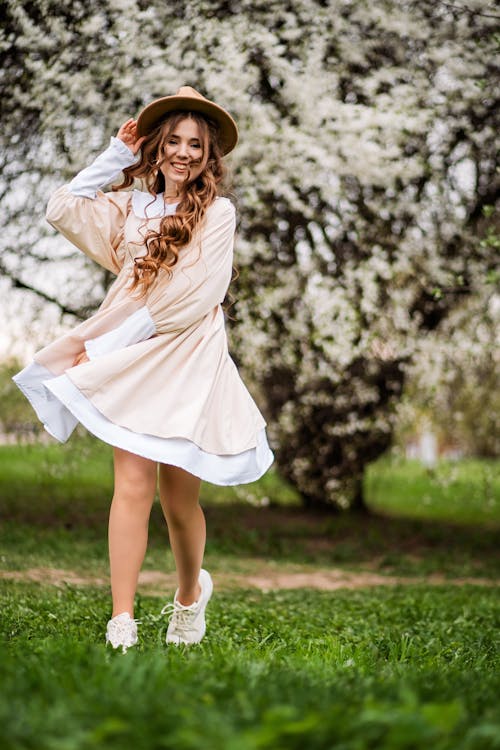 Beautiful Girl in Short Dress and Hat Cheerfully Dancing in Garden ...