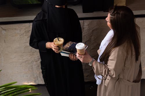 Free Women in Modesty Clothing Holding Coffee Cups Stock Photo