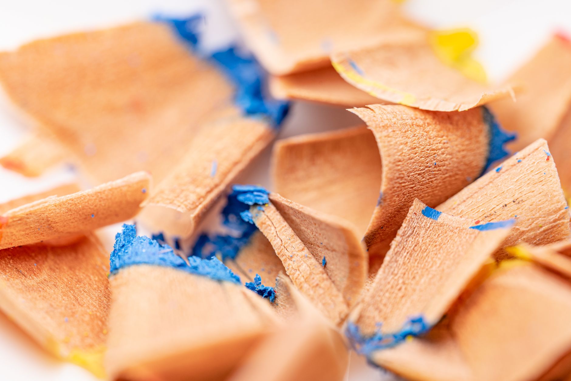 Detailed close-up of blue and yellow pencil shavings, artistic background.