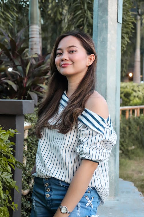 A Woman in White and Blue Stripe Off Shoulder Blouse