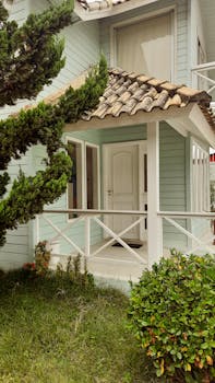 Peaceful view of a house entrance with a tiled roof and green surroundings.