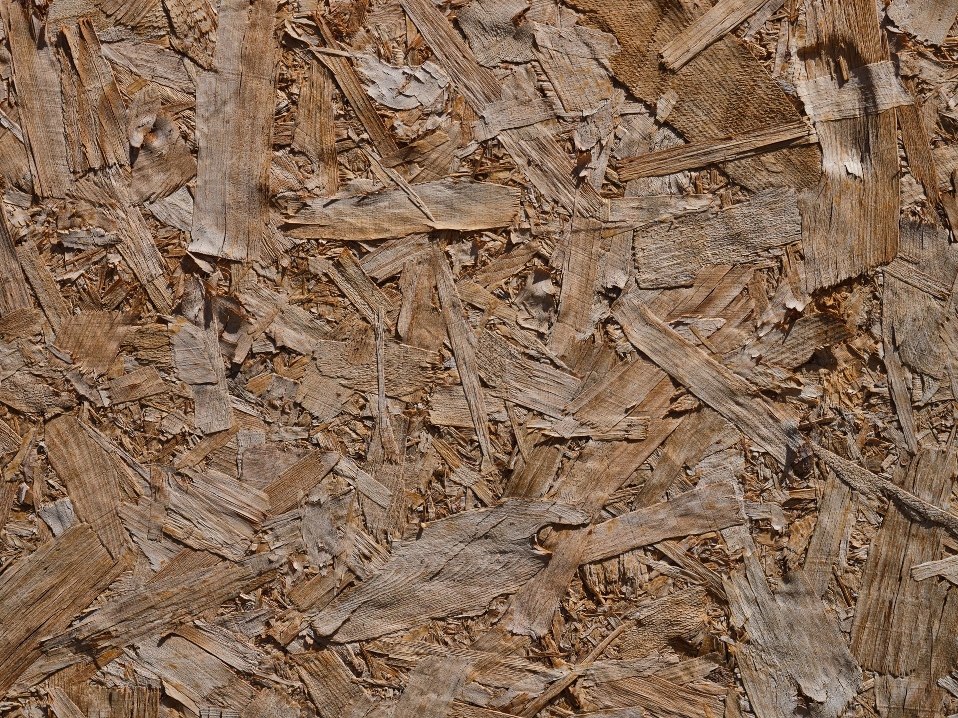Detailed close-up of a textured OSB wood surface showcasing patterns and natural hues.