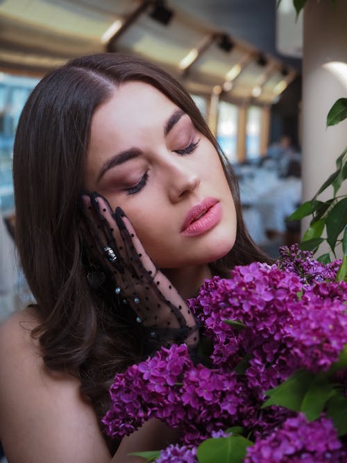 A Pretty Woman Beside Purple Flowers