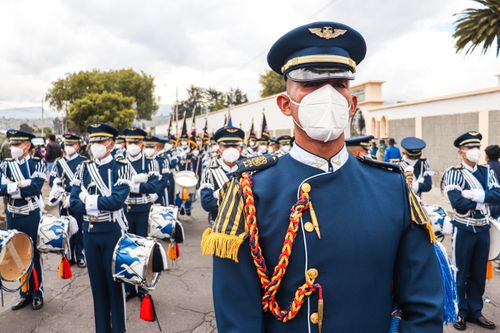 Free Ecuadorian military band marching in street parade, wearing uniforms and face masks. Stock Photo
