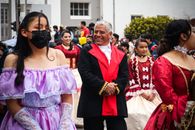 Man in Blue Academic Dress Standing Beside Woman in Pink and White Floral Dress