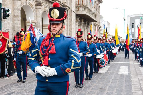 Free Ecuadorian soldiers march in a vibrant parade through city streets, showcasing military uniforms and national pride. Stock Photo