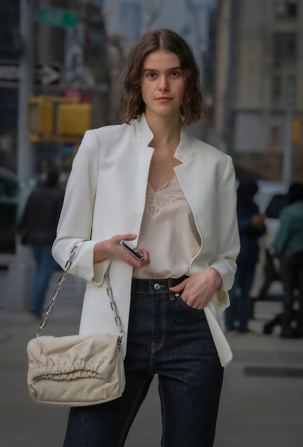 Woman in White Blazer and Blue Denim Jeans