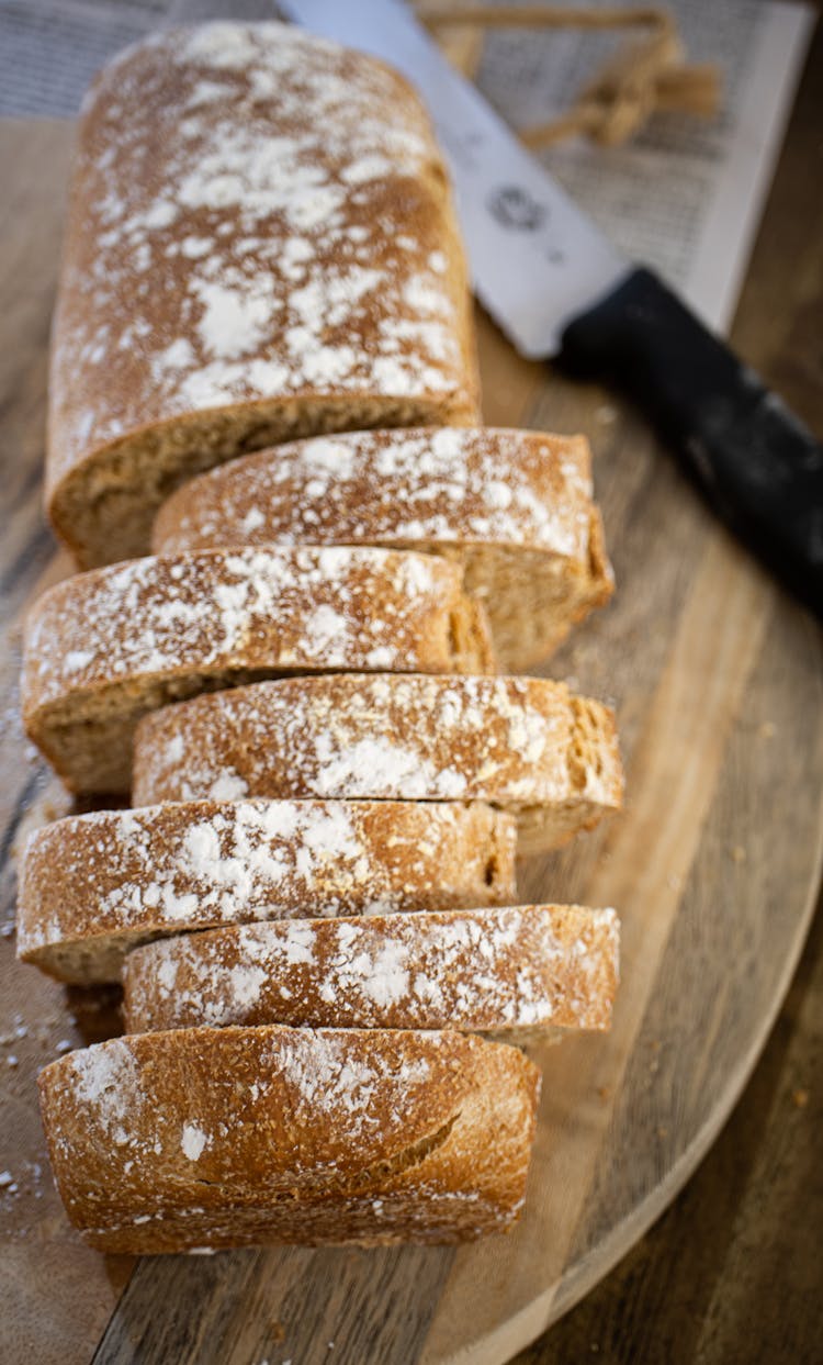 Photo Of A Sliced Bread, A Knife And A Cutting Board