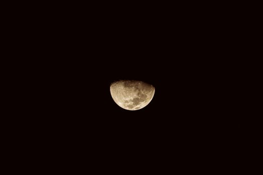 A captivating half-moon in sepia tones against a dark night sky, symbolizing tranquility and mystery.