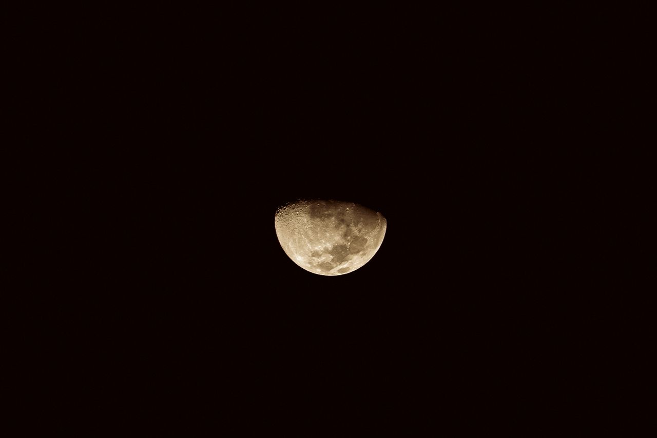 a captivating half moon in sepia tones against a dark night sky symbol