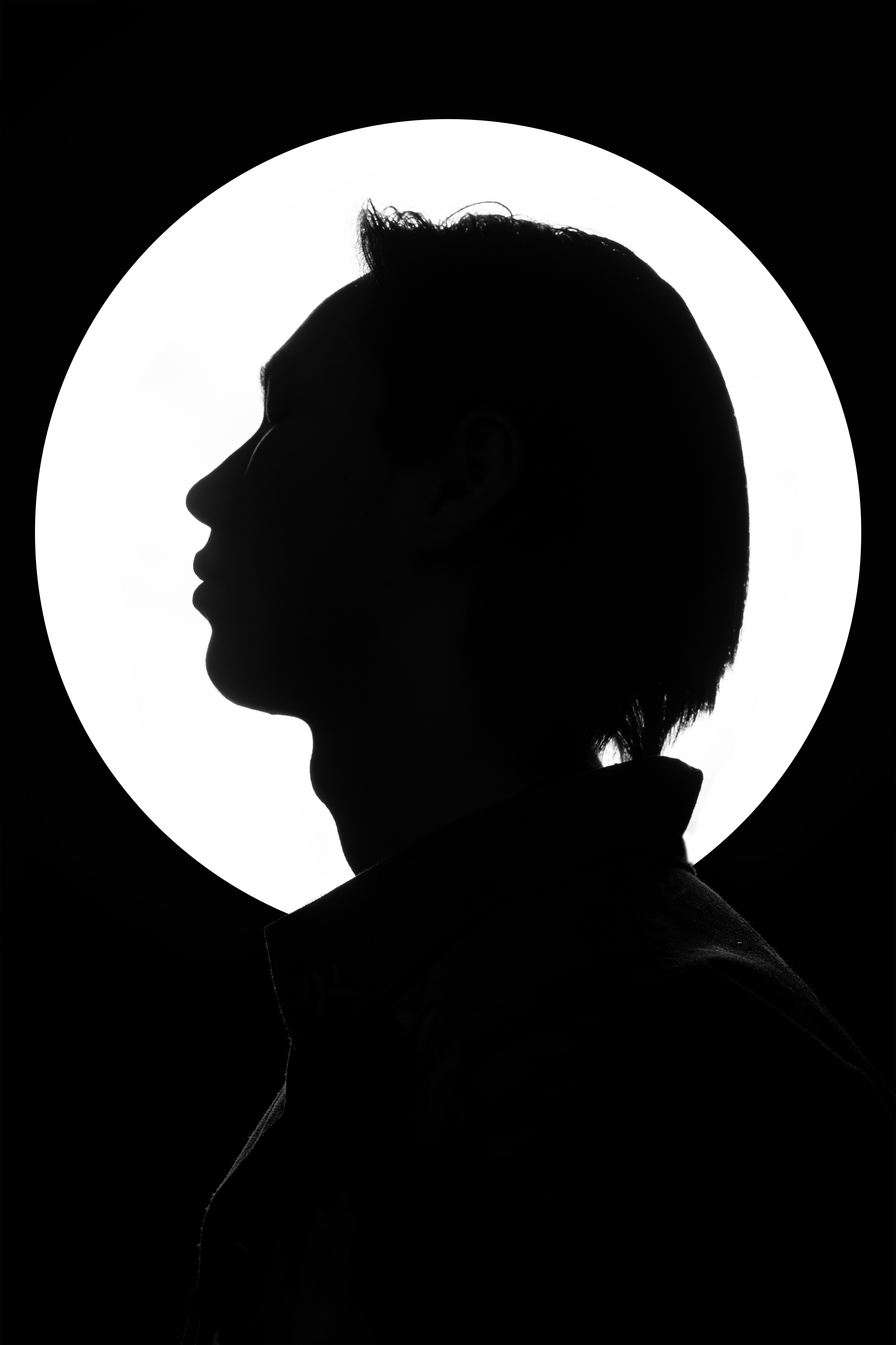 Striking black and white silhouette portrait with a bright background accentuating the profile.