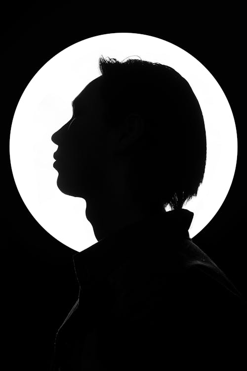 Free Silhouette of a  Person Head in Front of a Spotlight Stock Photo