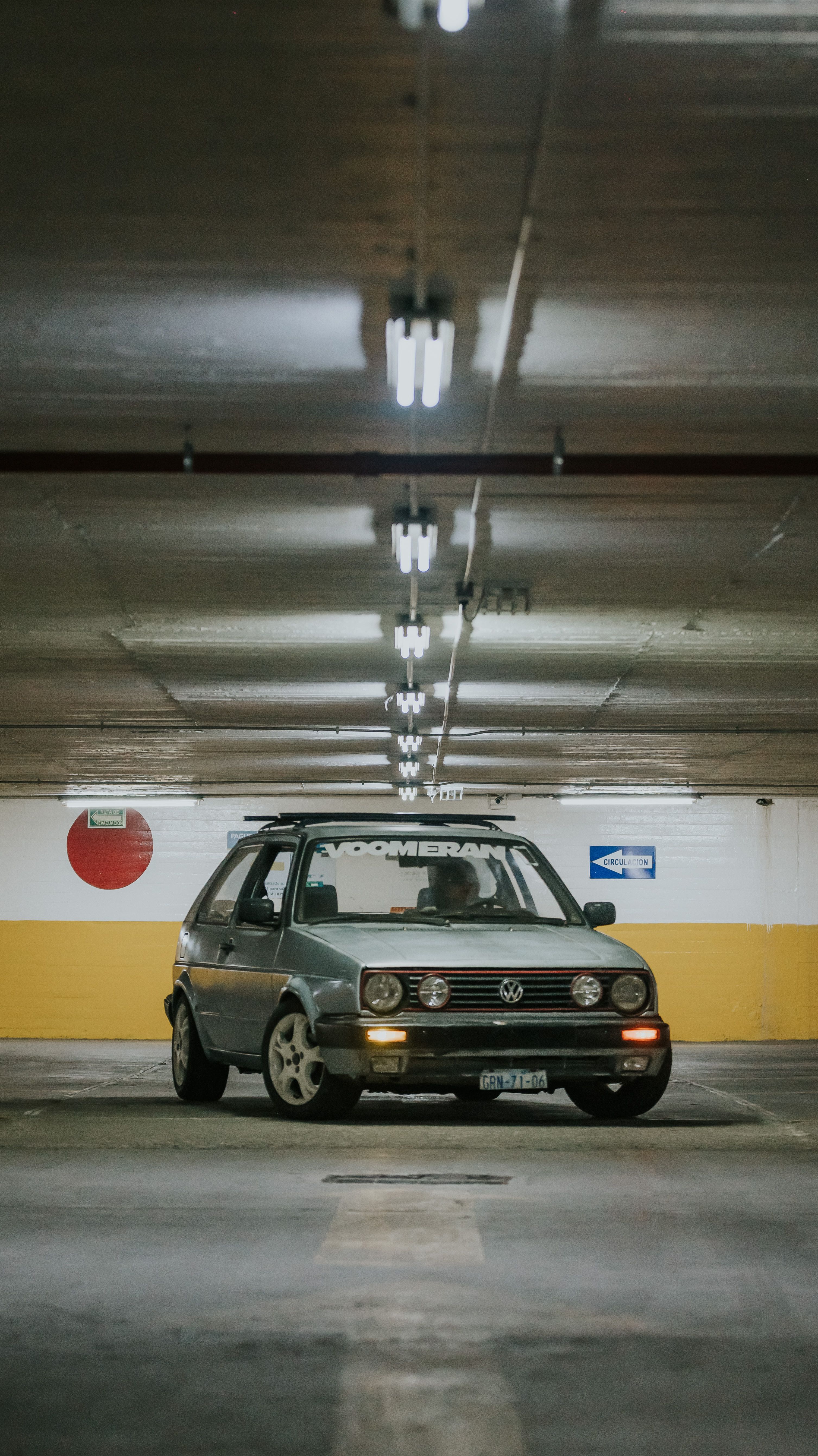 A classic Volkswagen car parked in an underground garage with ambient lighting.