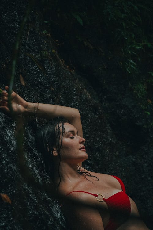 Sexy Woman in Red Bikini Top Leaning on Rock