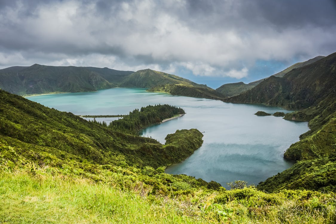Free Blue Lake Behind Green Mountain Under White Clouds Stock Photo