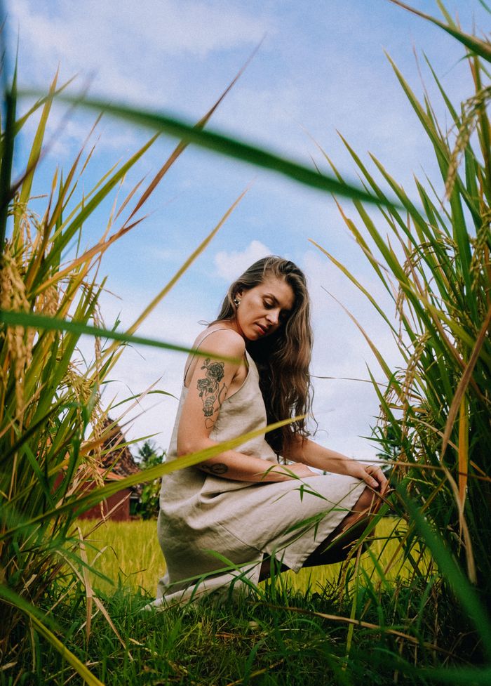 Woman in a linen dress in tall grass, photo by Ilya Batorshin on Pexels