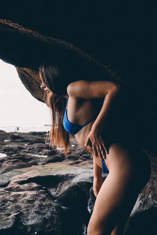 Sexy Woman in Blue Bikini Under the Rock