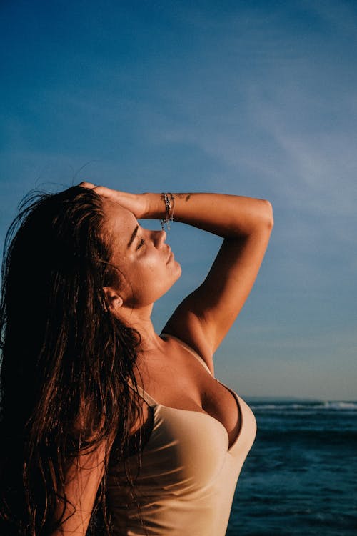 Beautiful Woman with Hand on Head in the Beach