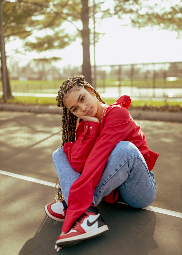 Model Girl With Many Pigtails Sitting Cross Legged On Road