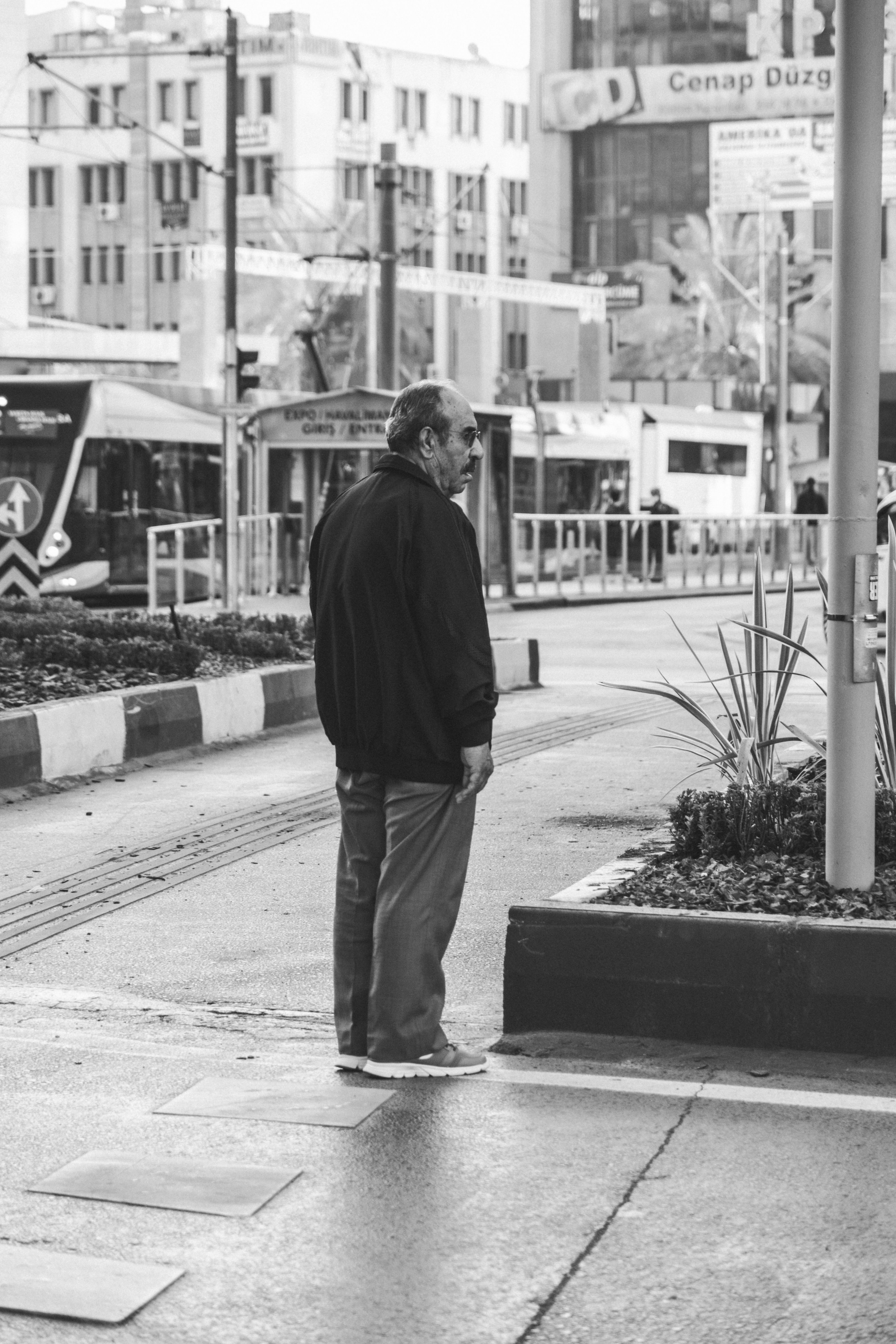 Black and White Photo of a Man Standing on the Sidewalk · Free Stock Photo