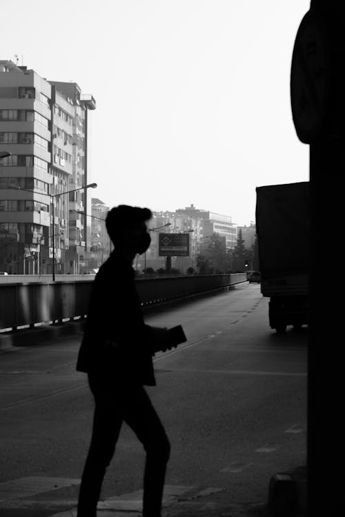 Silhouette of a Person Crossing the Street