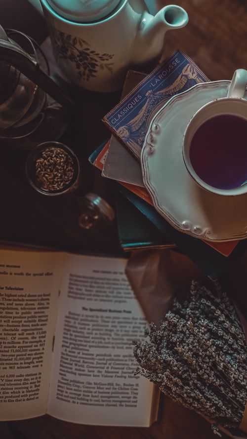 Free Serene tabletop scene with tea, books, and lavender, creating a cozy atmosphere. Stock Photo