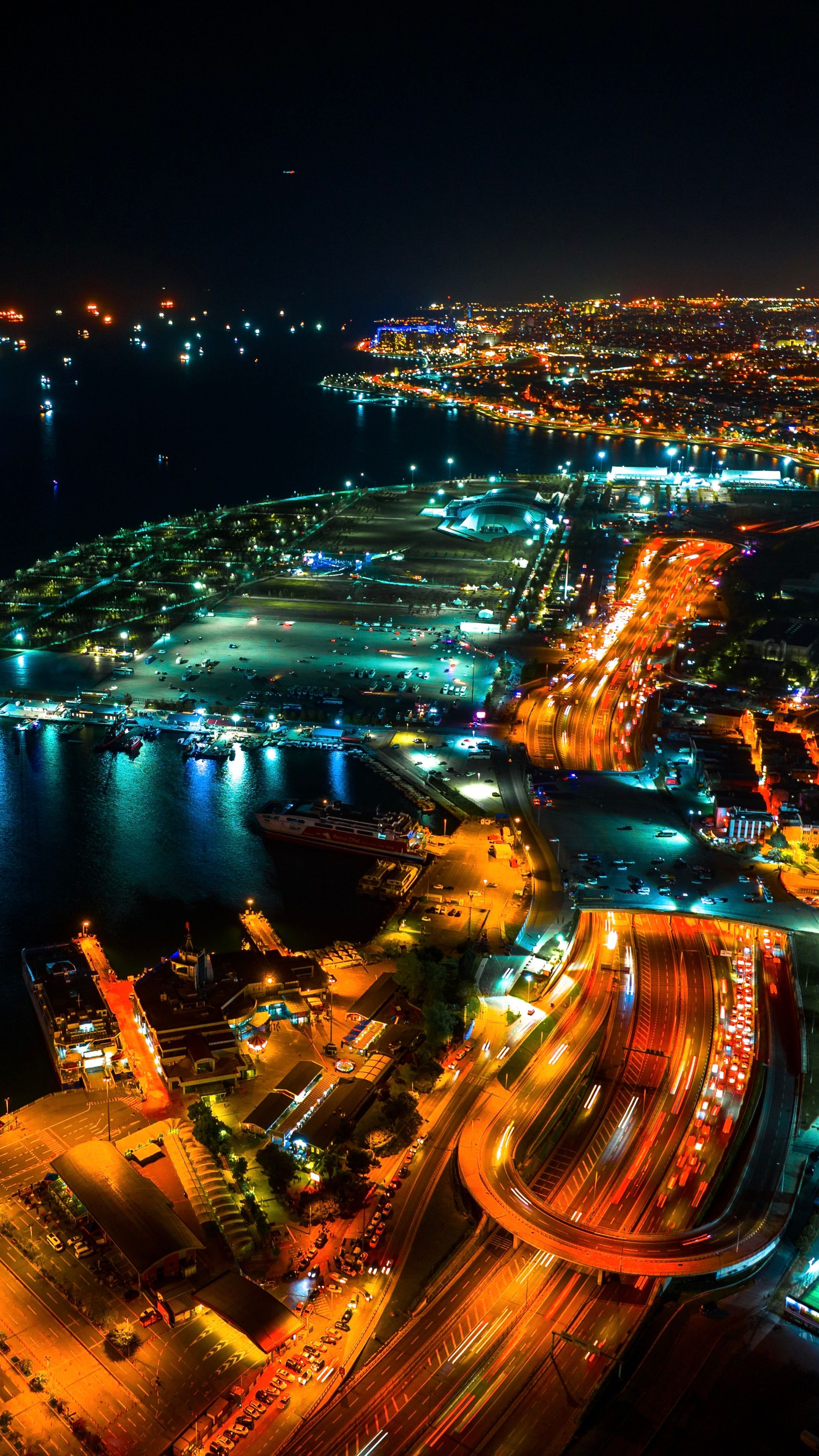 Stunning aerial night view showcasing Istanbul's illuminated cityscape and bustling harbor.