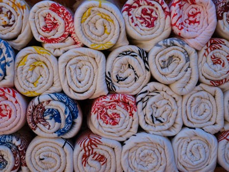 A close-up of colorful patterned towels neatly rolled and stacked, offering a cozy texture and design.