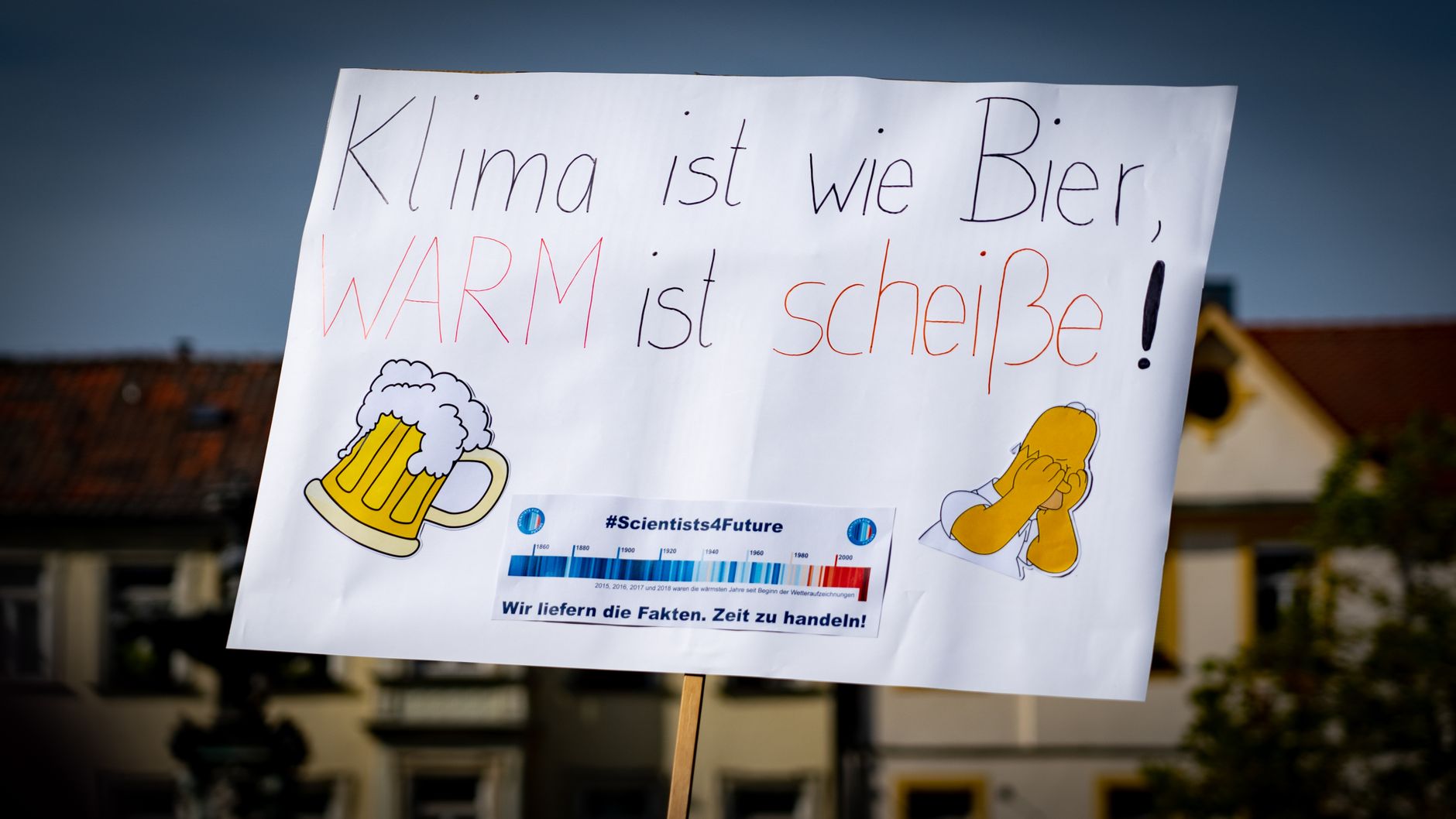 A humorous protest sign at a climate rally in Erlangen, Germany, likening climate to warm beer.