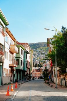 Explore a picturesque street lined with colorful facades, inviting you into a vibrant urban landscape under clear blue skies.