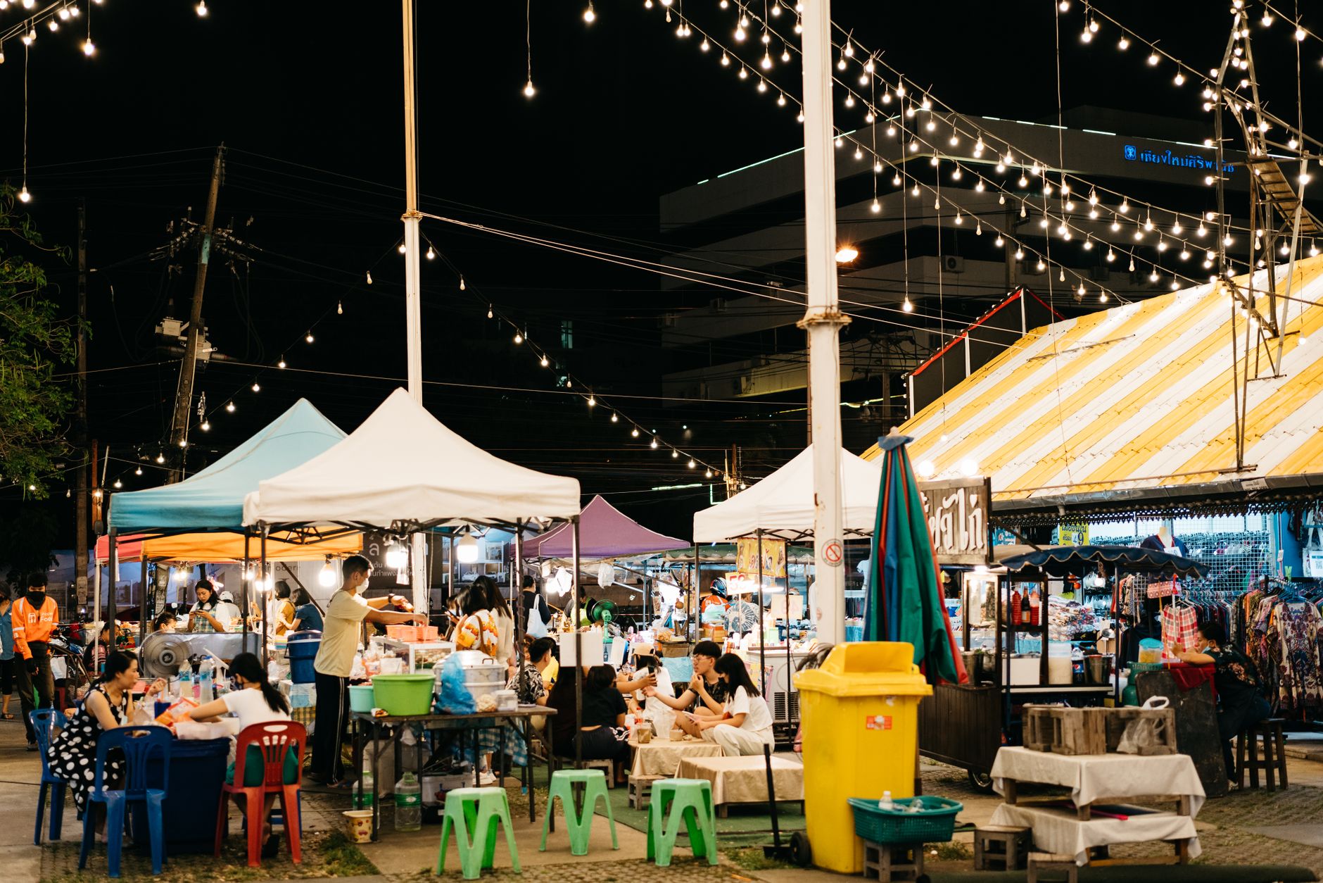 Silom Road at night with market stalls and office towers lit above