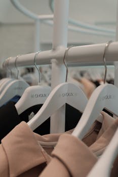 Close-up of clothing on hangers in a boutique displaying a minimalist aesthetic.